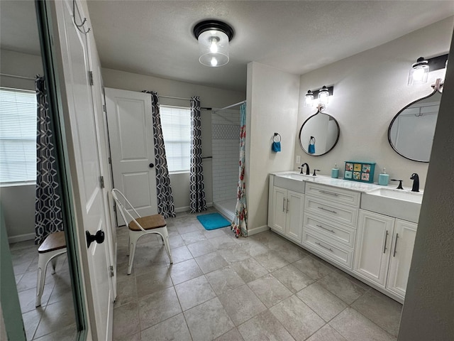 819 Beech St, Bonham, TX 75418 - bathroom featuring a tile shower, double vanity, and baseboards