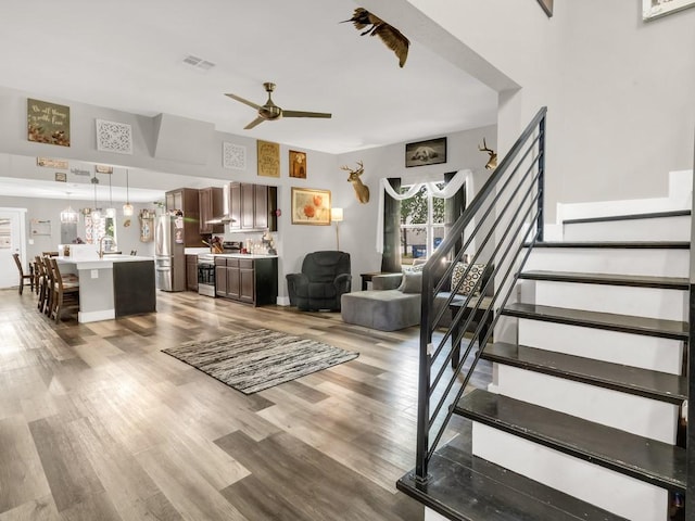 401 S 2nd St, Wortham, TX 76693 - living area featuring stairway, ceiling fan, and light wood-type flooring