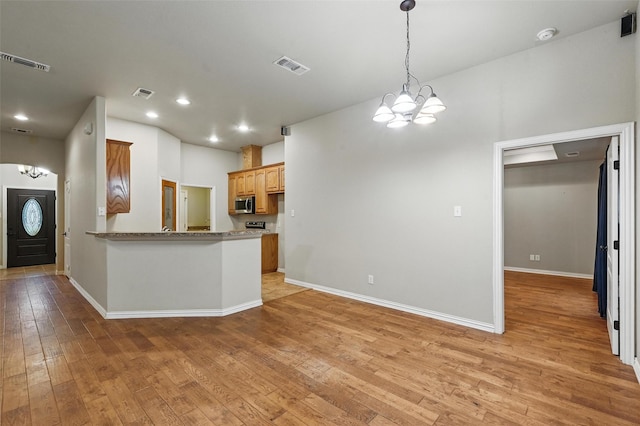 8109 County Road 804, Burleson, TX 76028 - kitchen with a chandelier, light wood finished floors, stainless steel microwave, a peninsula, and recessed lighting