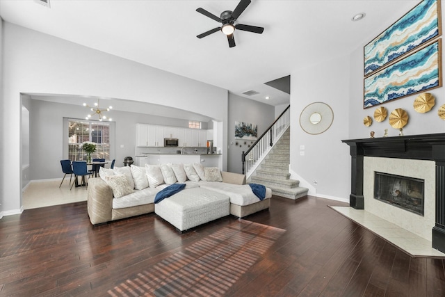 4304 Wildbriar Ln, Mansfield, TX 76063 - living area featuring a tiled fireplace, ceiling fan, hardwood / wood-style flooring, baseboards, and a chandelier