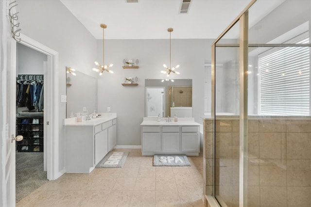 4304 Wildbriar Ln, Mansfield, TX 76063 - bathroom with a chandelier, two vanities, tile patterned floors, a stall shower, and a spacious closet