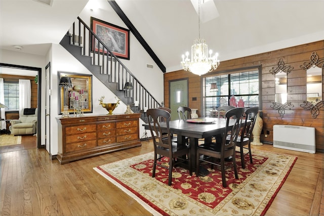 161 Cheyenne Dr, Nocona, TX 76255 - dining area with high vaulted ceiling, plenty of natural light, a chandelier, wood walls, and stairway