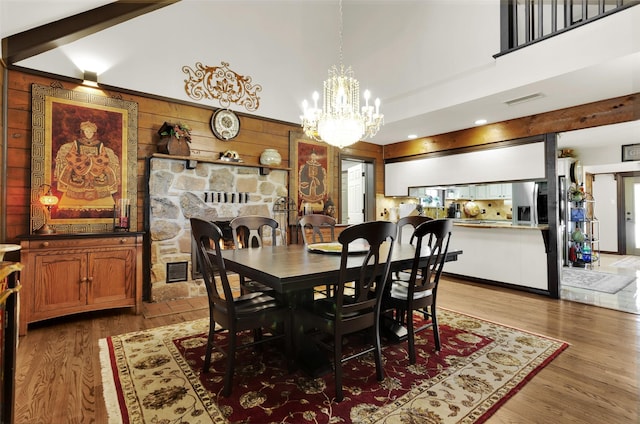 161 Cheyenne Dr, Nocona, TX 76255 - dining room featuring light wood-style flooring, wood walls, and a chandelier