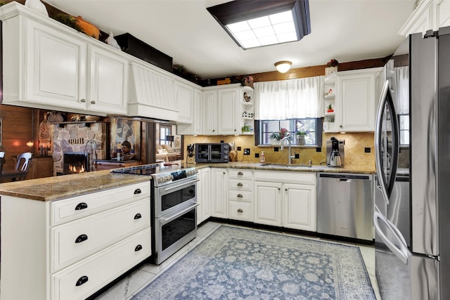 161 Cheyenne Dr, Nocona, TX 76255 - kitchen featuring stainless steel appliances, a sink, open shelves, decorative backsplash, and light stone counters