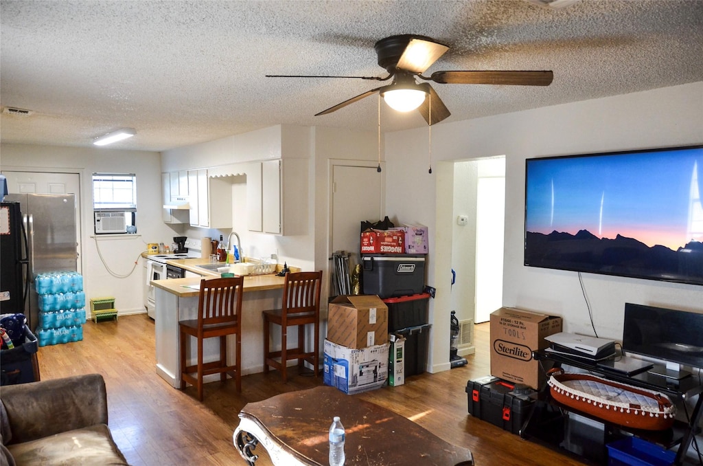 1025 Presidio, Abilene, TX 79605 - living area featuring wood finished floors, ceiling fan, a textured ceiling, and cooling unit