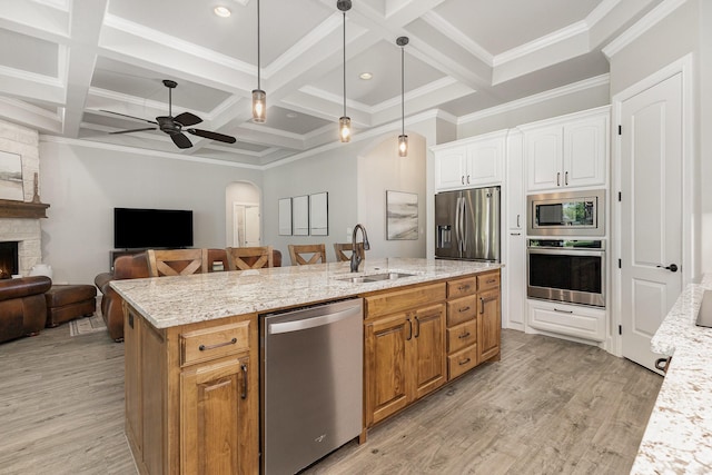3011 Skyhawk Dr, Granbury, TX 76049 - kitchen featuring appliances with stainless steel finishes, a sink, open floor plan, an island with sink, and beam ceiling
