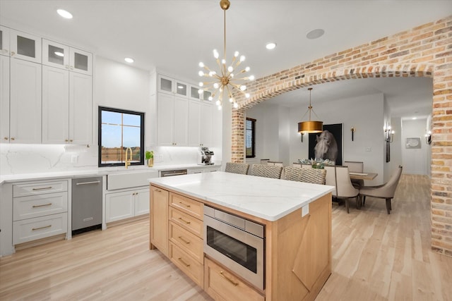 1911 Ozro Rd, Venus, TX 76084 - kitchen with stainless steel appliances, a sink, light wood finished floors, a kitchen island, and glass insert cabinets