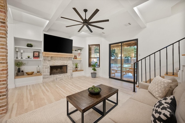1911 Ozro Rd, Venus, TX 76084 - living room with ceiling fan, wood finished floors, a stone fireplace, beam ceiling, and stairs