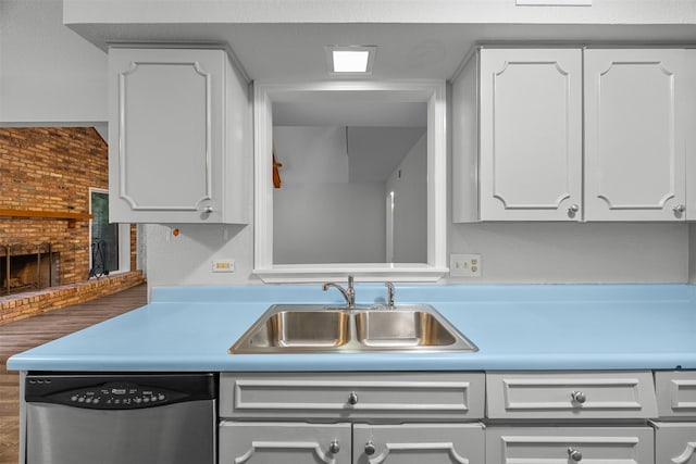 410 S Walnut Grove Rd, Midlothian, TX 76065 - kitchen featuring stainless steel dishwasher, a sink, white cabinetry, and a fireplace