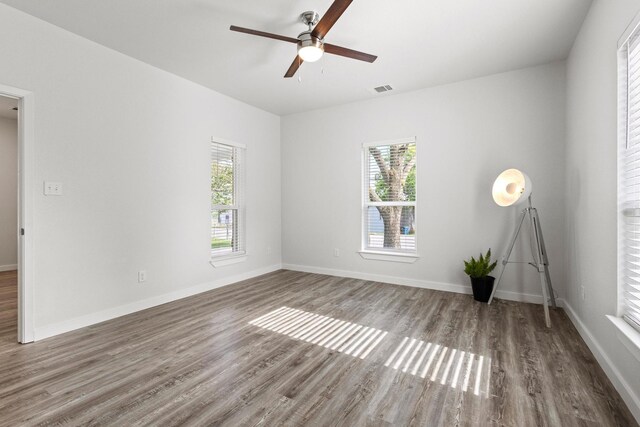 1005 W Bullock St, Denison, TX 75020 - spare room featuring plenty of natural light, wood finished floors, a ceiling fan, and baseboards