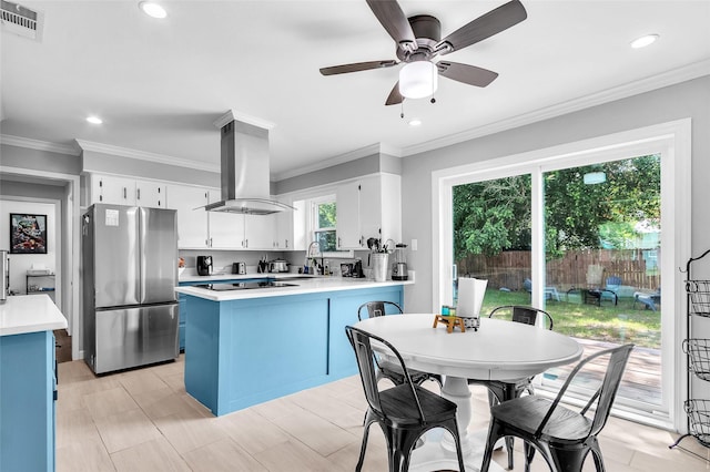 312 Dean St, Athens, TX 75751 - kitchen with freestanding refrigerator, island range hood, light countertops, a peninsula, and a sink