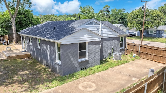 312 Dean St, Athens, TX 75751 - view of side of home with brick siding, roof with shingles, cooling unit, and view of wooded area