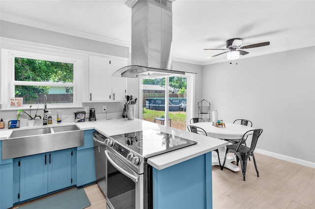 312 Dean St, Athens, TX 75751 - kitchen with blue cabinets, stainless steel appliances, a sink, island exhaust hood, and a peninsula