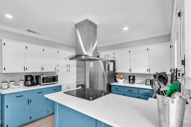 312 Dean St, Athens, TX 75751 - kitchen featuring blue cabinets, appliances with stainless steel finishes, island exhaust hood, white cabinetry, and crown molding