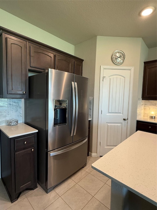 304 Olde Knoll Pl, Rio Vista, TX 76093 - kitchen with stainless steel fridge, light countertops, decorative backsplash, dark brown cabinets, and a textured ceiling