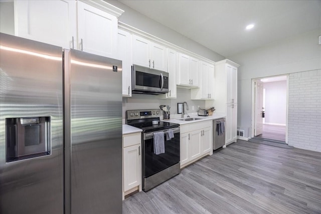 5401 Odom Ave, Fort Worth, TX 76114 - kitchen with stainless steel appliances, a sink, light countertops, light wood-type flooring, and white cabinets