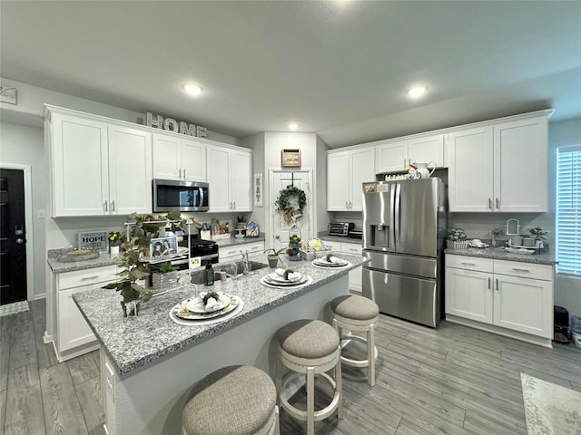 608 N Rain Barrel Pl, Weston, TX 75009 - kitchen featuring appliances with stainless steel finishes, a sink, recessed lighting, white cabinets, and light wood-style floors