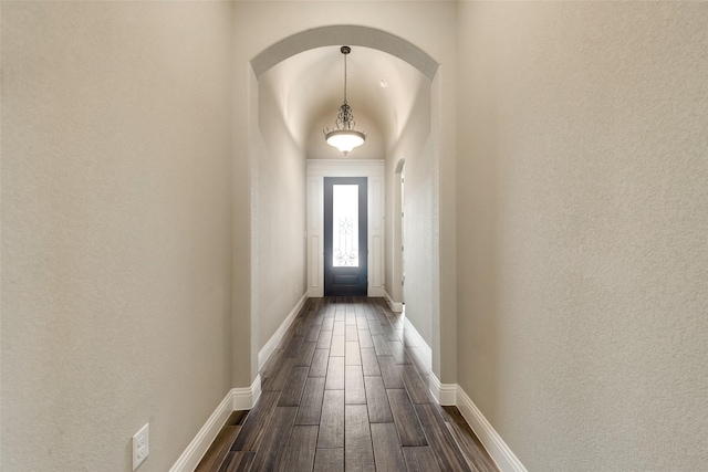 3201 Windcrest Dr, Granbury, TX 76049 - doorway featuring dark wood-style floors, baseboards, a textured wall, and arched walkways