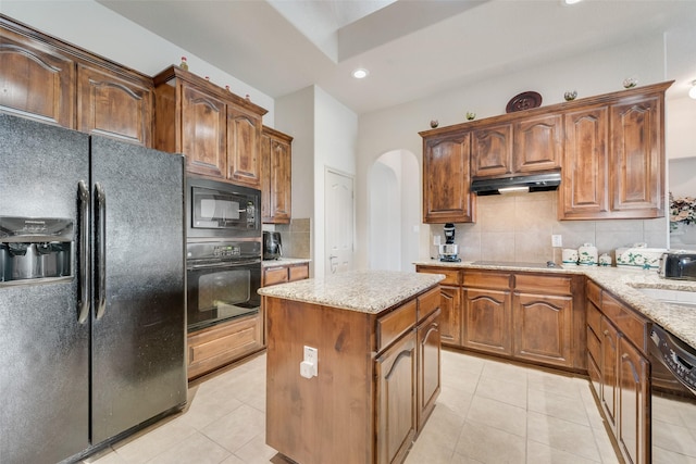 1322 Turnbridge Dr, Glenn Heights, TX 75154 - kitchen featuring black appliances, arched walkways, under cabinet range hood, light tile patterned floors, and recessed lighting