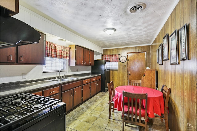2825 Warren Ave, Dallas, TX 75215 - kitchen with black appliances, a sink, extractor fan, dark countertops, and wood walls