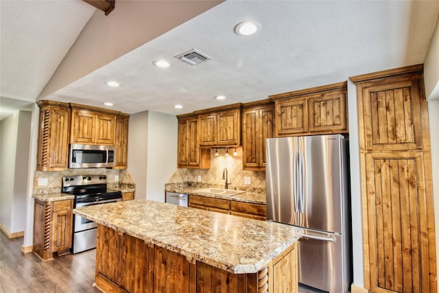 1214 Vivienne St, Weatherford, TX 76086 - kitchen featuring appliances with stainless steel finishes, a sink, recessed lighting, a kitchen island, and dark wood-style flooring
