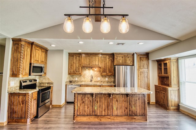 1214 Vivienne St, Weatherford, TX 76086 - kitchen featuring stainless steel appliances, lofted ceiling, a sink, a kitchen island, and light stone counters