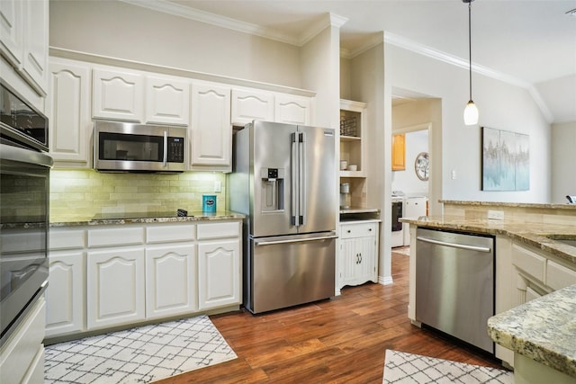 3606 Four Trees Dr, Weatherford, TX 76087 - kitchen featuring stainless steel appliances, washing machine and clothes dryer, crown molding, white cabinetry, and hanging light fixtures