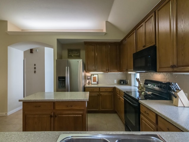 8205 Rayburn Ln, Mckinney, TX 75072 - kitchen featuring black appliances, light tile patterned flooring, arched walkways, and backsplash