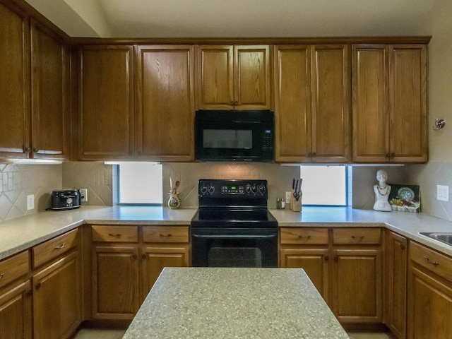 8205 Rayburn Ln, Mckinney, TX 75072 - kitchen featuring black appliances, light countertops, decorative backsplash, and brown cabinetry