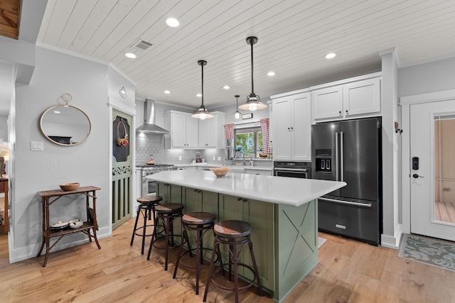 828 Crooked Creek Rd, Edgewood, TX 75117 - kitchen featuring appliances with stainless steel finishes, wall chimney exhaust hood, light countertops, white cabinetry, and a center island