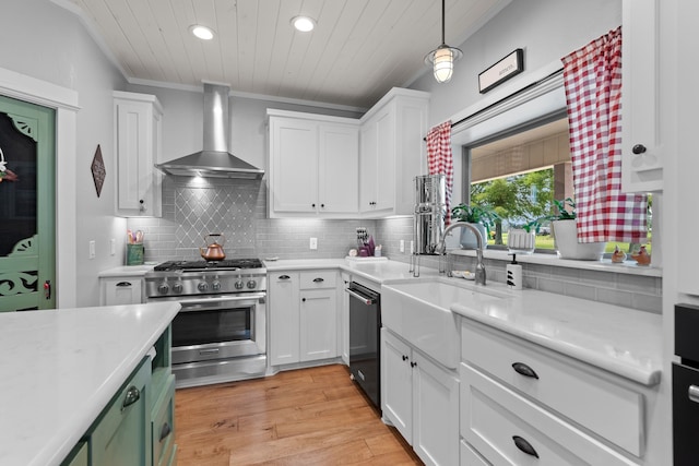 828 Crooked Creek Rd, Edgewood, TX 75117 - kitchen with wall chimney range hood, stainless steel range with gas cooktop, a sink, dishwashing machine, and recessed lighting