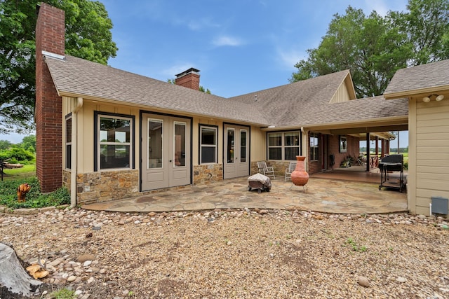 828 Crooked Creek Rd, Edgewood, TX 75117 - rear view of house with a chimney, stone siding, a shingled roof, and a patio
