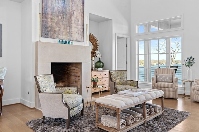 13390 Waterside Dr, Malakoff, TX 75148 - living area with wood finished floors, a fireplace, a high ceiling, and baseboards