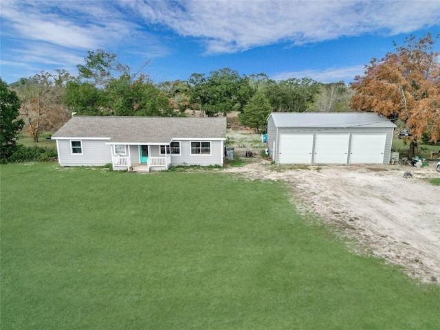 23899 Sagewood Ln, Bedias, TX 77831 - single story home featuring a detached garage, a front yard, an outdoor structure, a porch, and view of wooded area