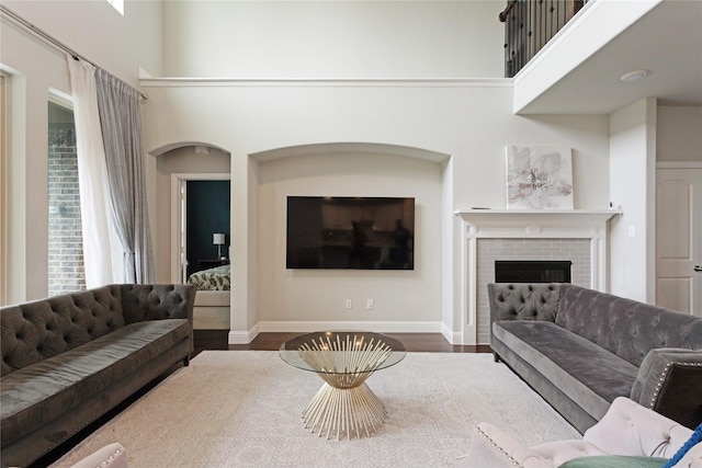 11408 Morrow Ln, Mckinney, TX 75071 - living room with wood finished floors, a brick fireplace, and a high ceiling