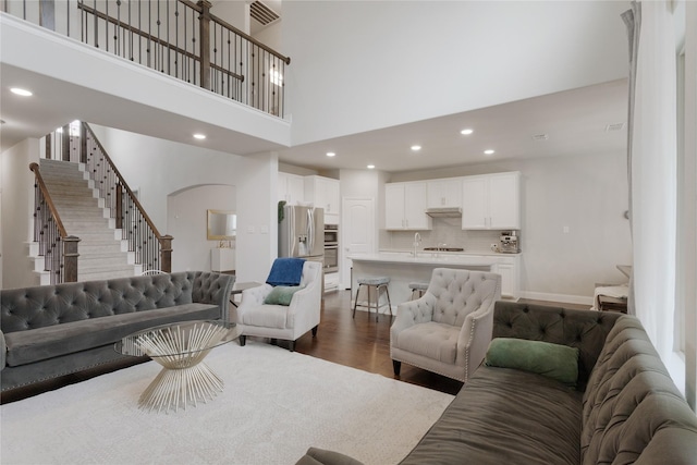 11408 Morrow Ln, Mckinney, TX 75071 - living area with stairs, dark wood-style flooring, recessed lighting, arched walkways, and a high ceiling
