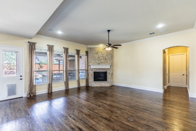7132 Jernigan Dr, Frisco, TX 75034 - unfurnished living room featuring a ceiling fan, crown molding, a fireplace, dark wood finished floors, and arched walkways