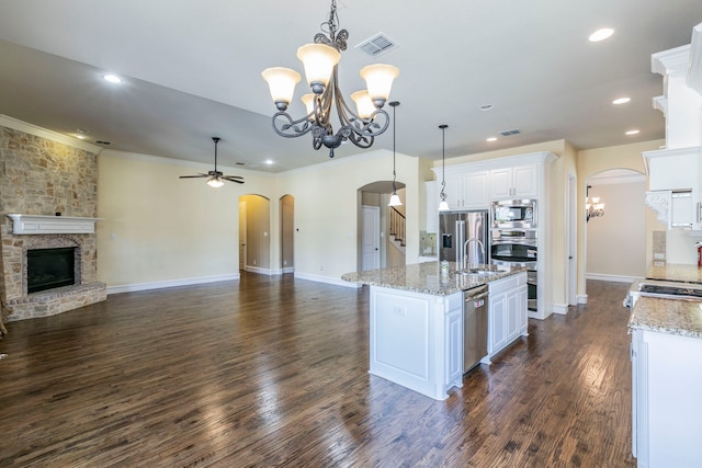 7132 Jernigan Dr, Frisco, TX 75034 - kitchen featuring stainless steel appliances, arched walkways, open floor plan, a chandelier, and crown molding