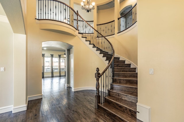 7132 Jernigan Dr, Frisco, TX 75034 - staircase with arched walkways, wood finished floors, a chandelier, and a high ceiling