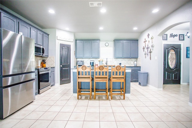 131 Live Oak Ln, Decatur, TX 76234 - kitchen with stainless steel appliances, arched walkways, decorative backsplash, recessed lighting, and light tile patterned flooring