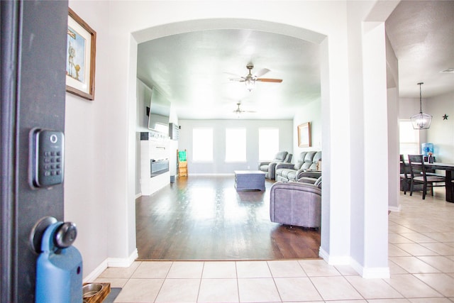 131 Live Oak Ln, Decatur, TX 76234 - living room featuring ceiling fan, light tile patterned floors, arched walkways, and baseboards