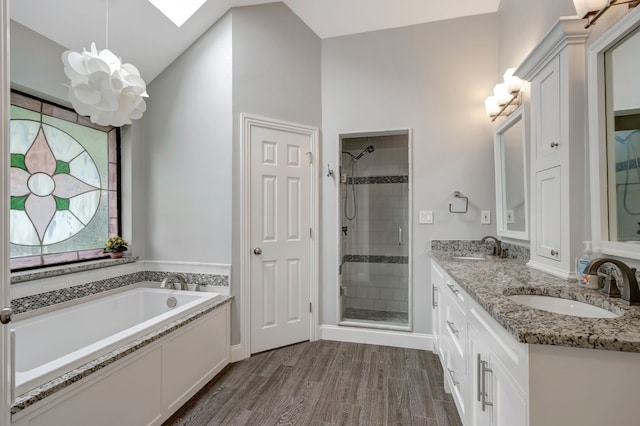 2049 Liverpool Dr, Plano, TX 75025 - bathroom featuring a stall shower, a chandelier, a bath, double vanity, and wood finished floors