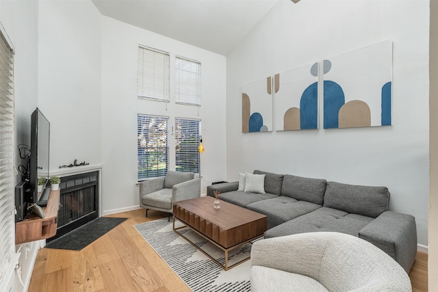 5335 Bent Tree Forest Dr Unit 302, Dallas, TX 75248 - living room with high vaulted ceiling, wood finished floors, a fireplace with flush hearth, and baseboards