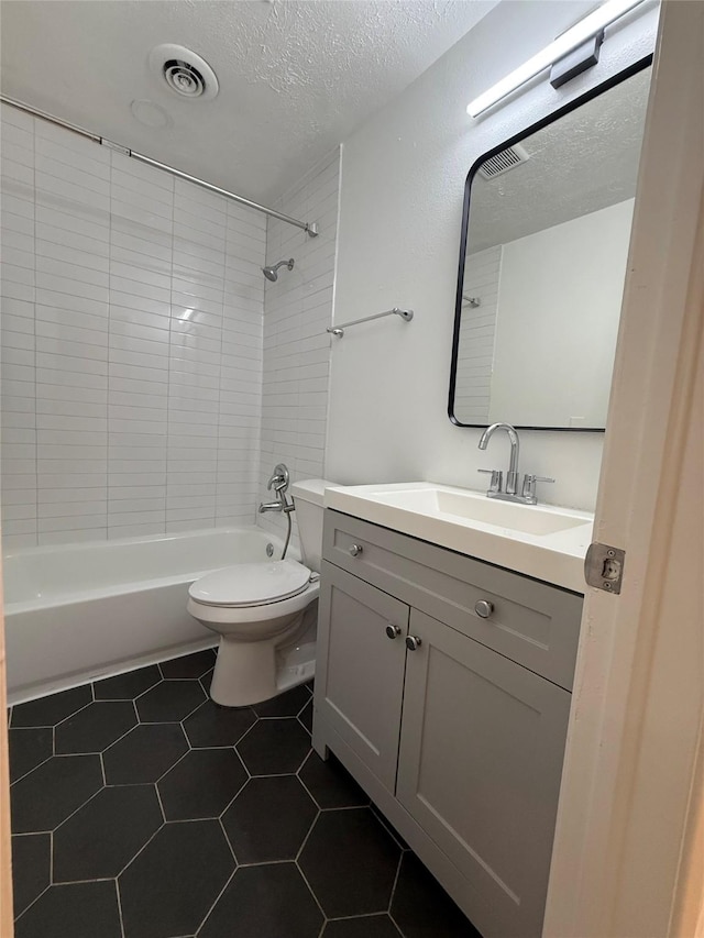 1833 Hood St, Carrollton, TX 75006 - bathroom featuring shower / bathtub combination, vanity, a textured ceiling, toilet, and tile patterned flooring