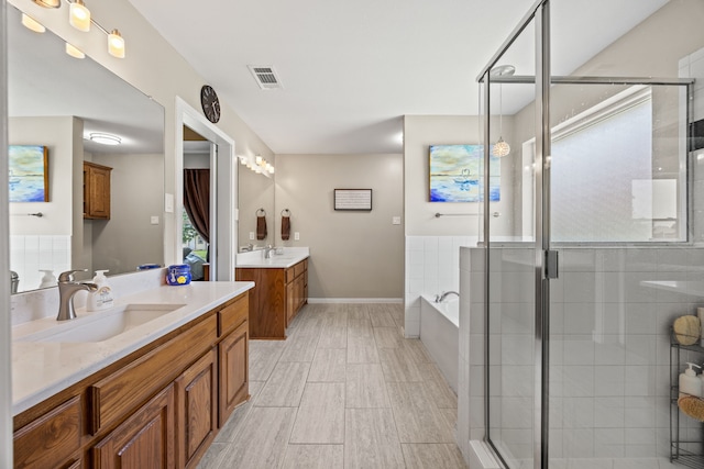 1329 E Highland Rd, Waxahachie, TX 75167 - full bath featuring two vanities, a shower stall, a garden tub, and wood finished floors