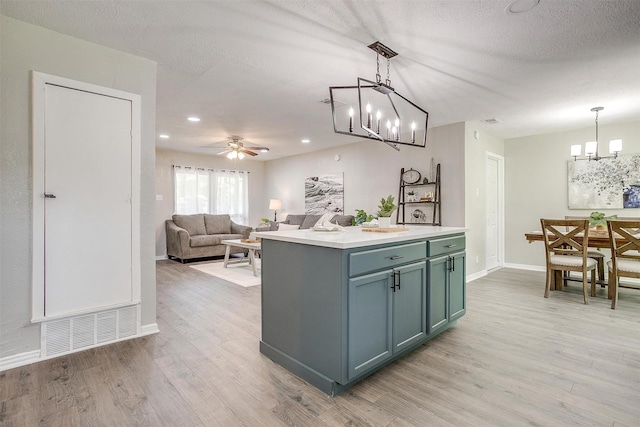1909 Balla Way, Grand Prairie, TX 75051 - kitchen featuring a chandelier, light wood finished floors, light countertops, ceiling fan, and decorative light fixtures