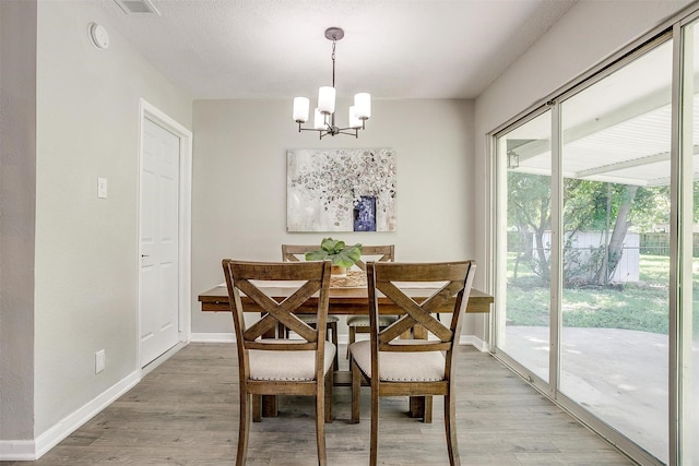 1909 Balla Way, Grand Prairie, TX 75051 - dining area with a chandelier, light wood finished floors, and baseboards