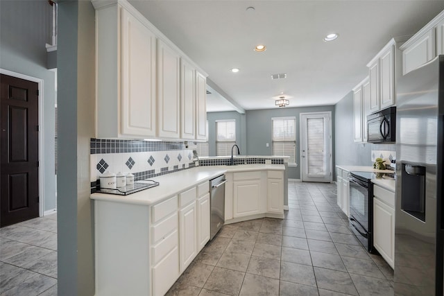 1635 Southwestern Dr, Allen, TX 75013 - kitchen with black appliances, decorative backsplash, recessed lighting, a peninsula, and light countertops