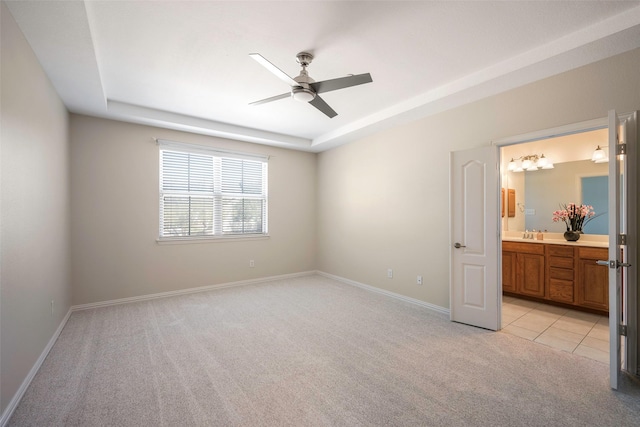 1635 Southwestern Dr, Allen, TX 75013 - unfurnished bedroom with light carpet, a raised ceiling, baseboards, connected bathroom, and a sink