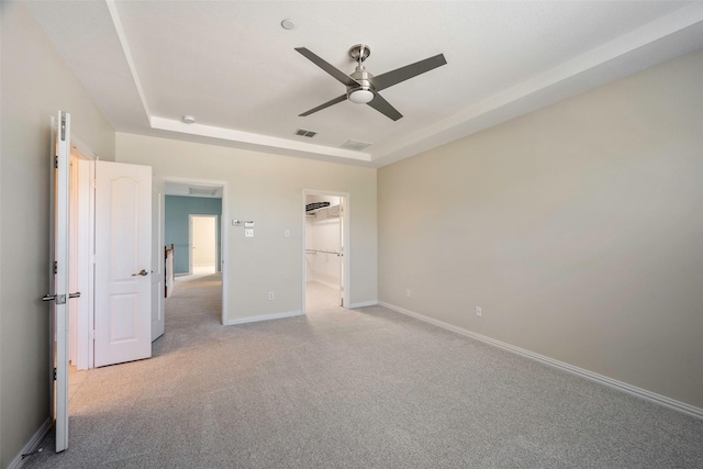 1635 Southwestern Dr, Allen, TX 75013 - unfurnished bedroom with light colored carpet, baseboards, a ceiling fan, a tray ceiling, and a spacious closet